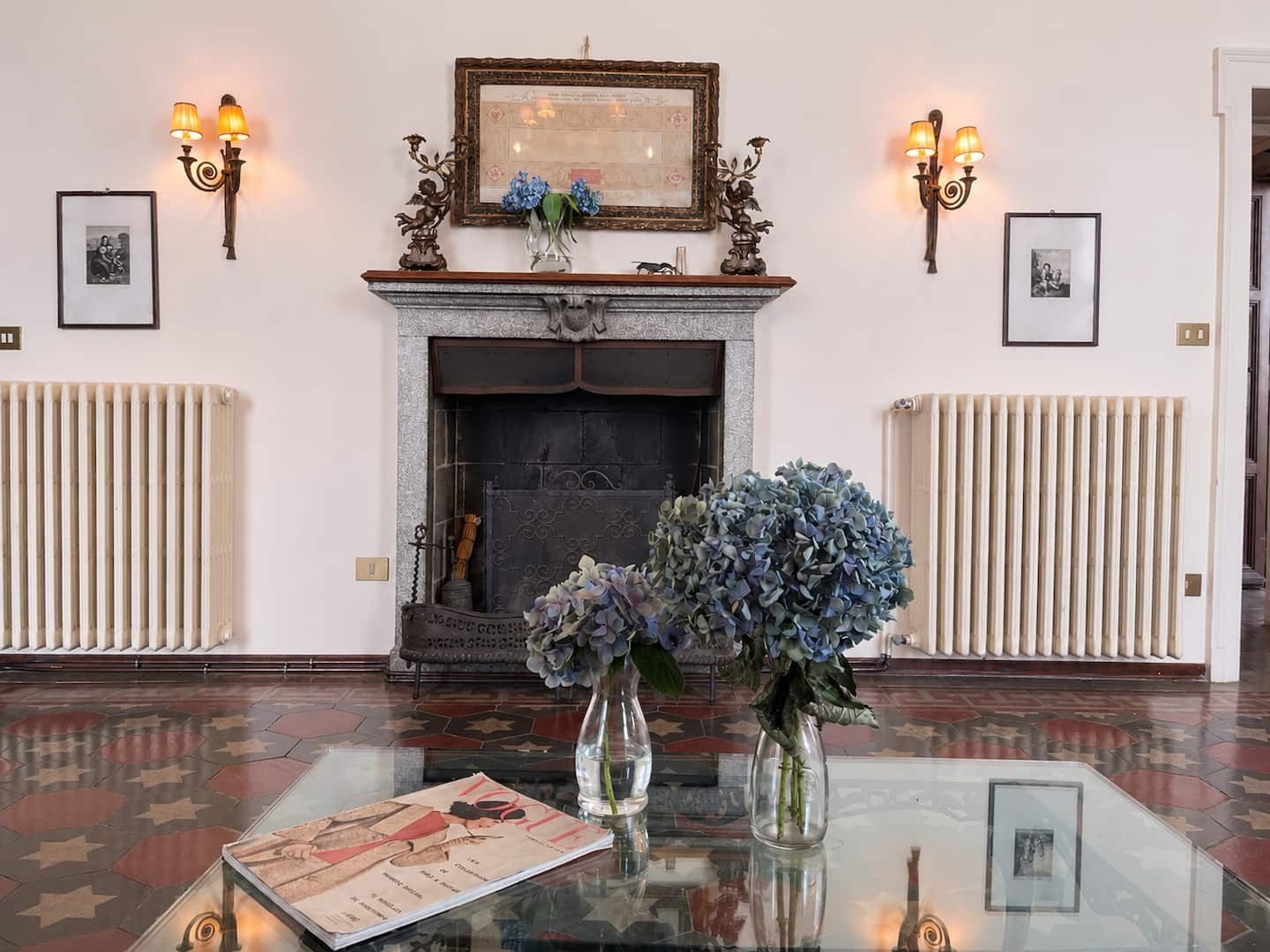The living room fireplace with hydrangeas on a glass table