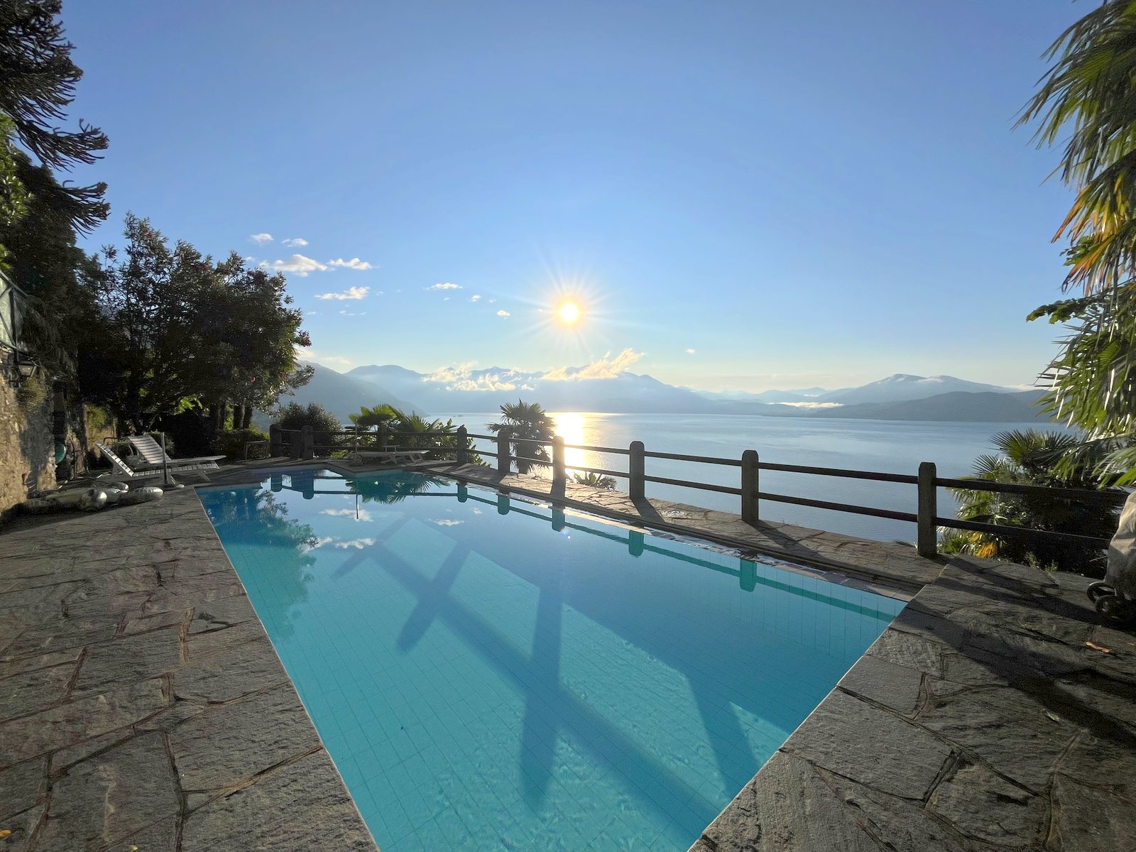 The pool terrace in morning light, the lake beyond